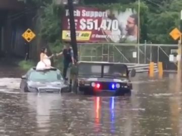 La novia escapa de la inundación con el vestido de novia puesto La novia escapa de la inundación con el vestido de novia puesto