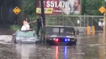 La novia escapa de la inundación con el vestido de novia puesto