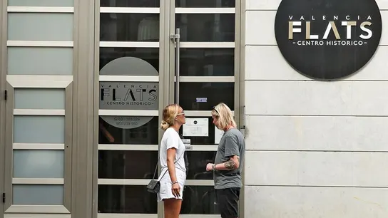 Una pareja de turistas se dispone a entrar en edificio de apartamentos  Una pareja de turistas se dispone a entrar en edificio de apartamentos