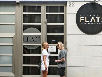 Una pareja de turistas se dispone a entrar en edificio de apartamentos Una pareja de turistas se dispone a entrar en edificio de apartamentos