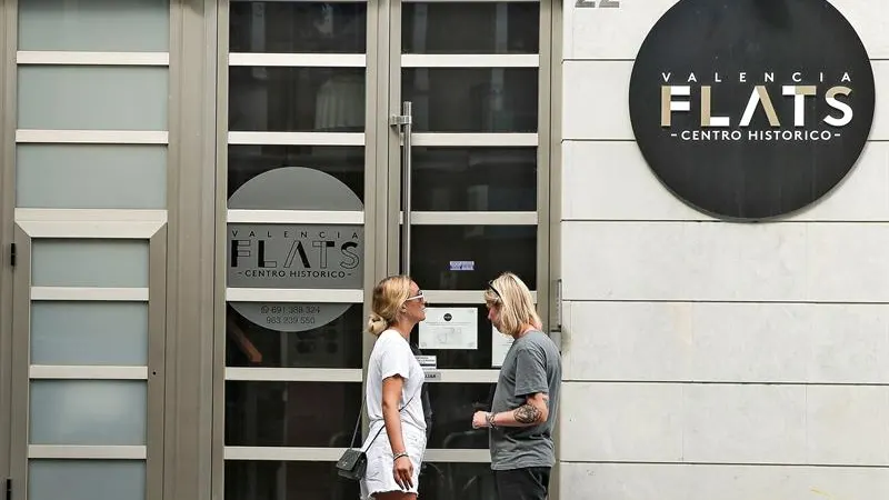 Una pareja de turistas se dispone a entrar en edificio de apartamentos 