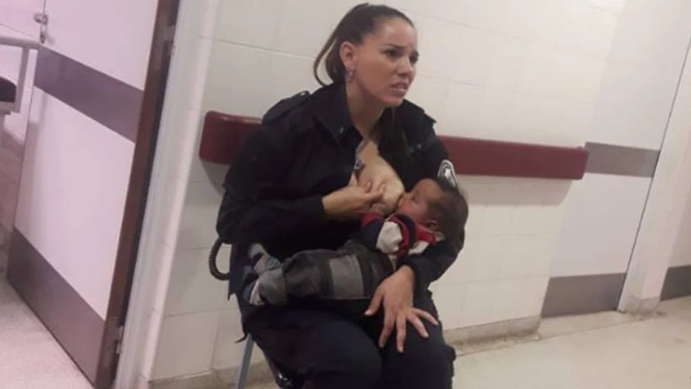 Imagen de una policía amamantando a un bebé Imagen de una policía amamantando a un bebé