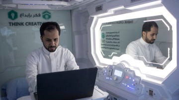 Un peregrino hajj musulmán utiliza su ordenador dentro de su habitación/cápsula en un hotel móvil dispuesto en La Meca