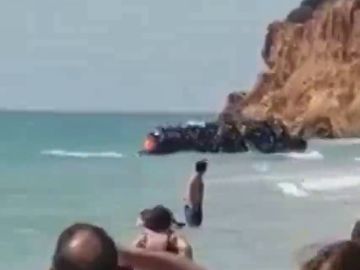 BORRADOR Unos 50 migrantes llegan a una playa de Chiclana en una zodiac ante la atenta mirada de los bañistas BORRADOR Unos 50 migrantes llegan a una playa de Chiclana en una zodiac ante la atenta mirada de los bañistas