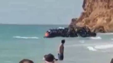 BORRADOR Unos 50 migrantes llegan a una playa de Chiclana en una zodiac ante la atenta mirada de los bañistas