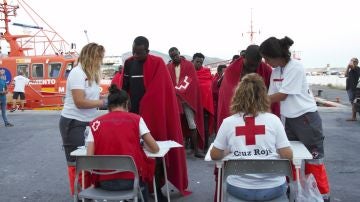 Miembros de la Cruz Roja atienden a decenas de migrantes rescatados por Salvamento Marítimo de una patera en la cercanías de la Isla de Alborán
