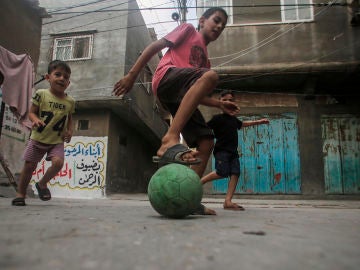 Niños palestinos jugando fútbol en un campo de refugiados Niños palestinos jugando fútbol en un campo de refugiados