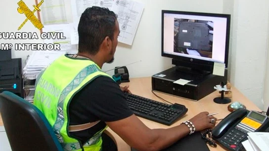Un agente de la Guardia Civil incautando material pornográfico infantil Un agente de la Guardia Civil incautando material pornográfico infantil
