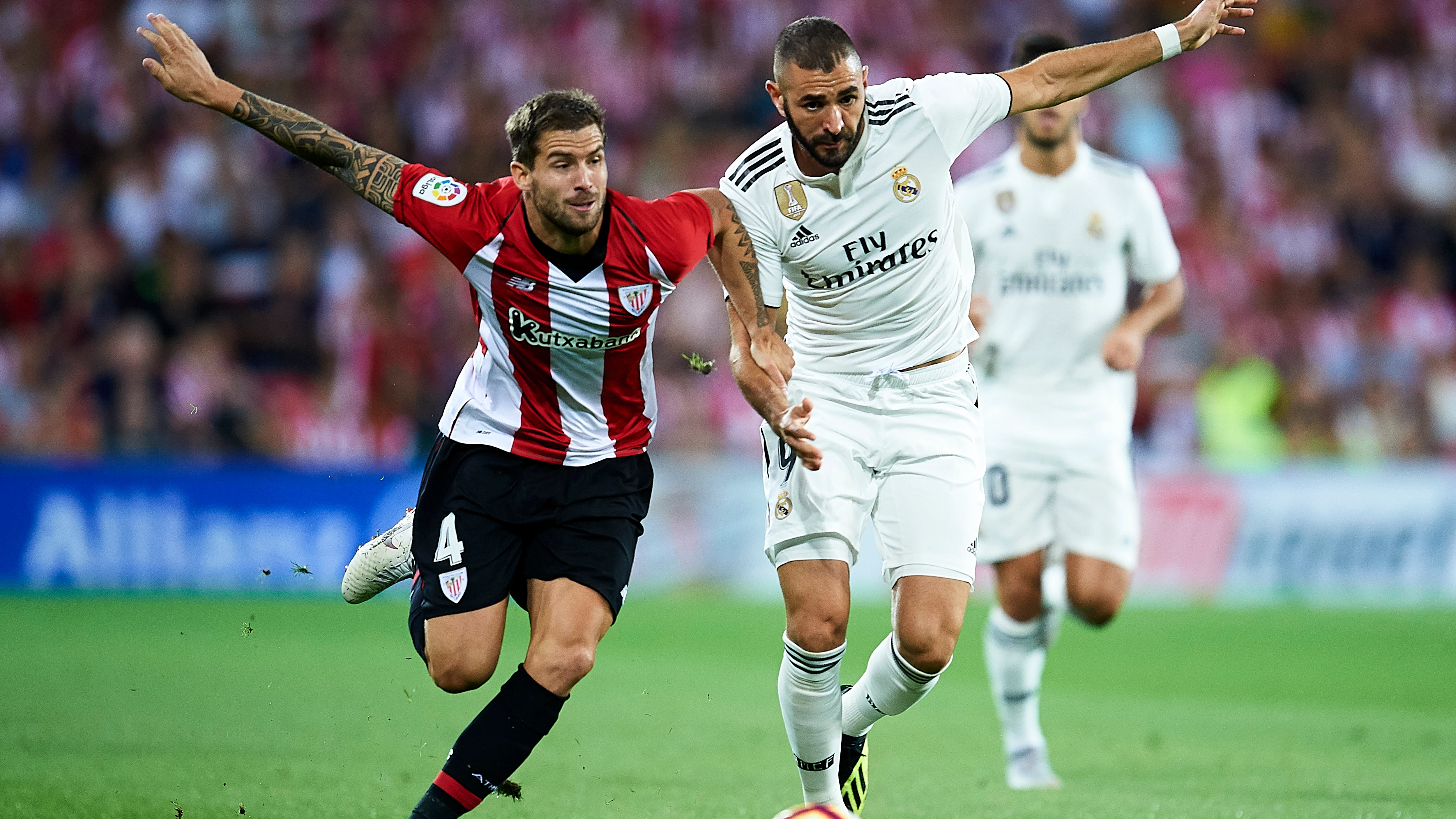 Iñigo Martínez y Benzema se disputan la posesión del balón