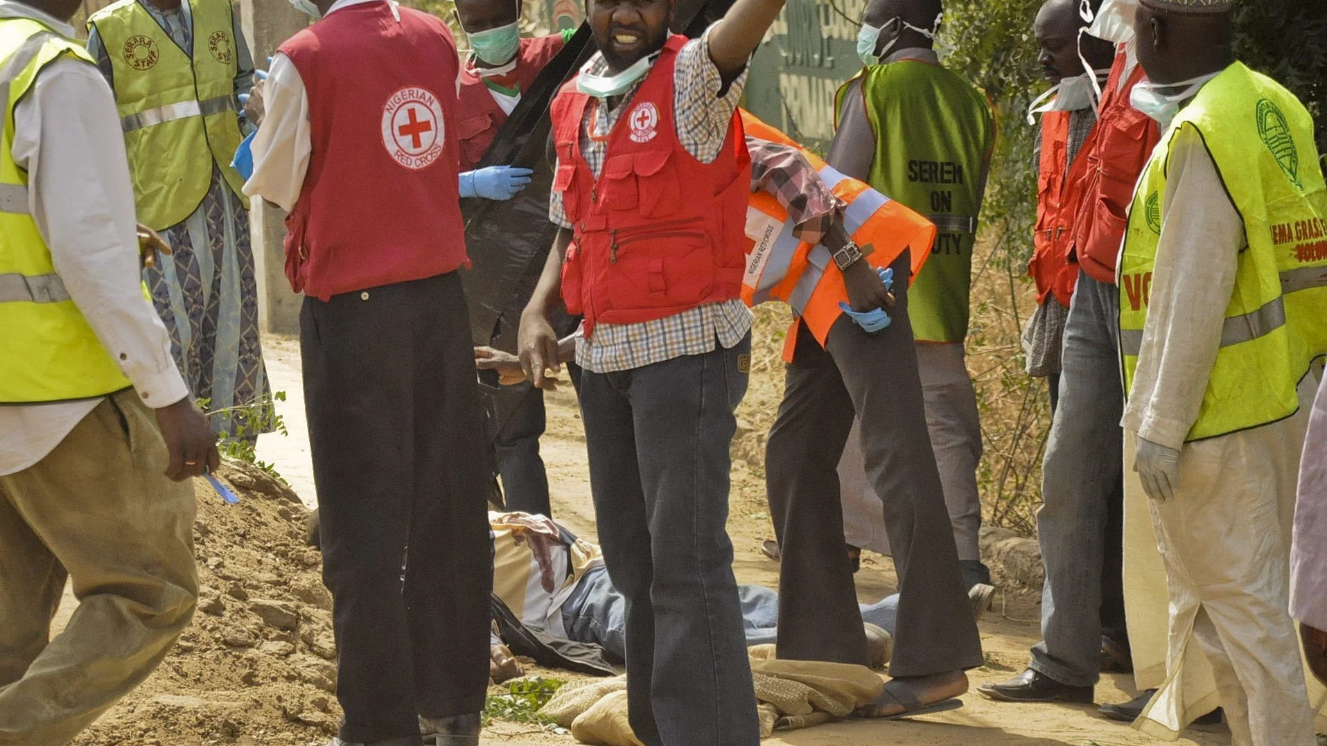 Miembros de la Cruz Roja y de la Agencia Nacional de Emergencias de Nigeria (NEMA), trasladando el cuerpo de una víctima, en la ciudad septentrional nigeriana de Kano