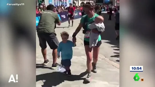 Una madre llega a la meta con sus hijos durante una carrera Una madre llega a la meta con sus hijos durante una carrera