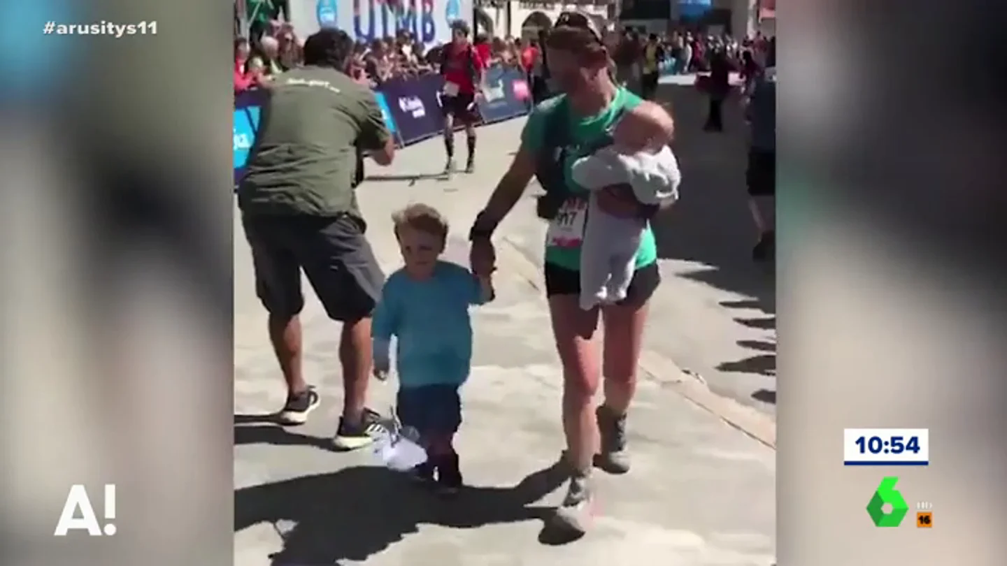 Una madre llega a la meta con sus hijos durante una carrera Una madre llega a la meta con sus hijos durante una carrera