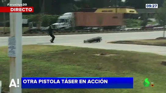 Un policía dispara a un delincuente con una pistola taser Un policía dispara a un delincuente con una pistola taser