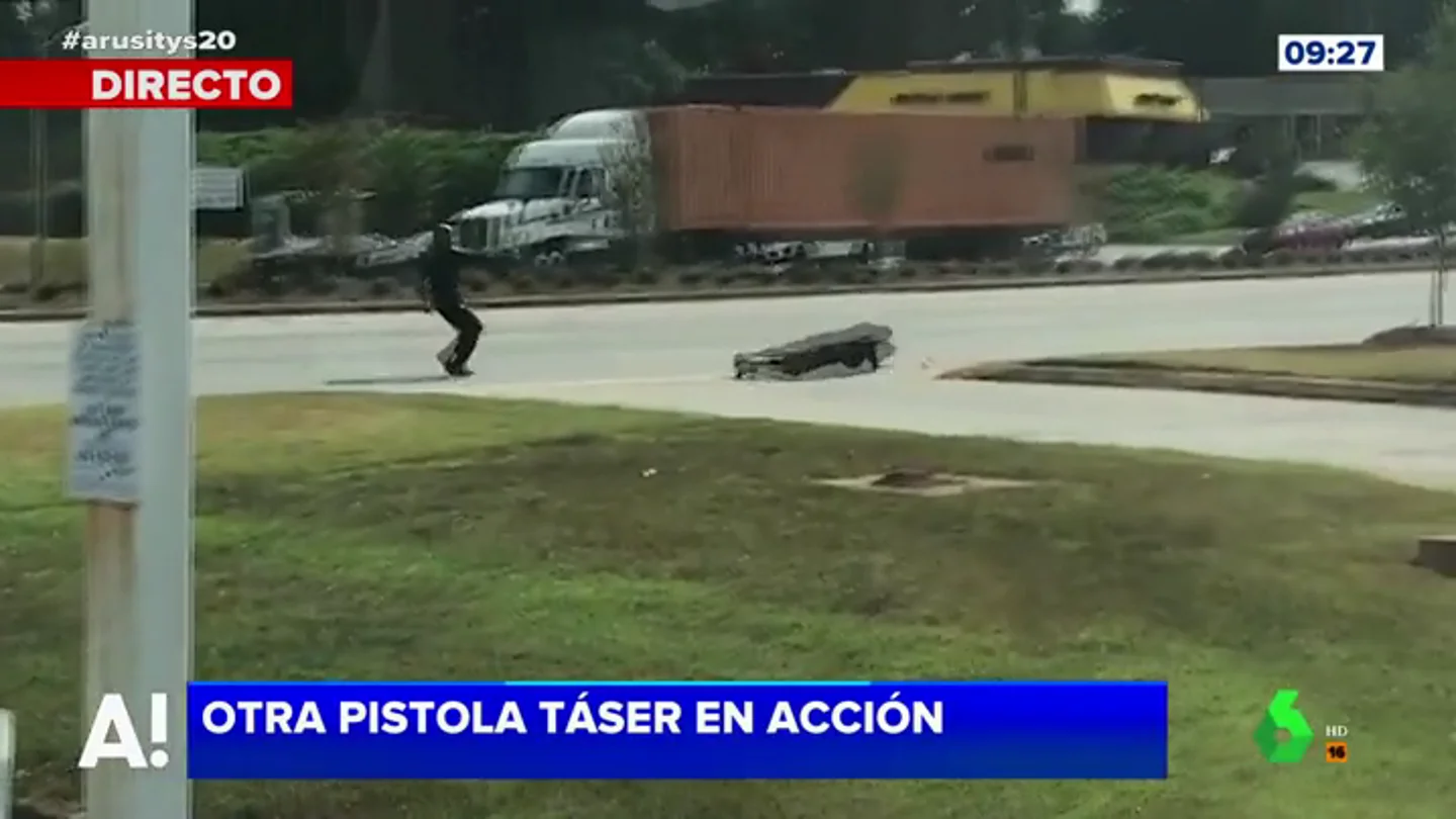 Un policía dispara a un delincuente con una pistola taser Un policía dispara a un delincuente con una pistola taser