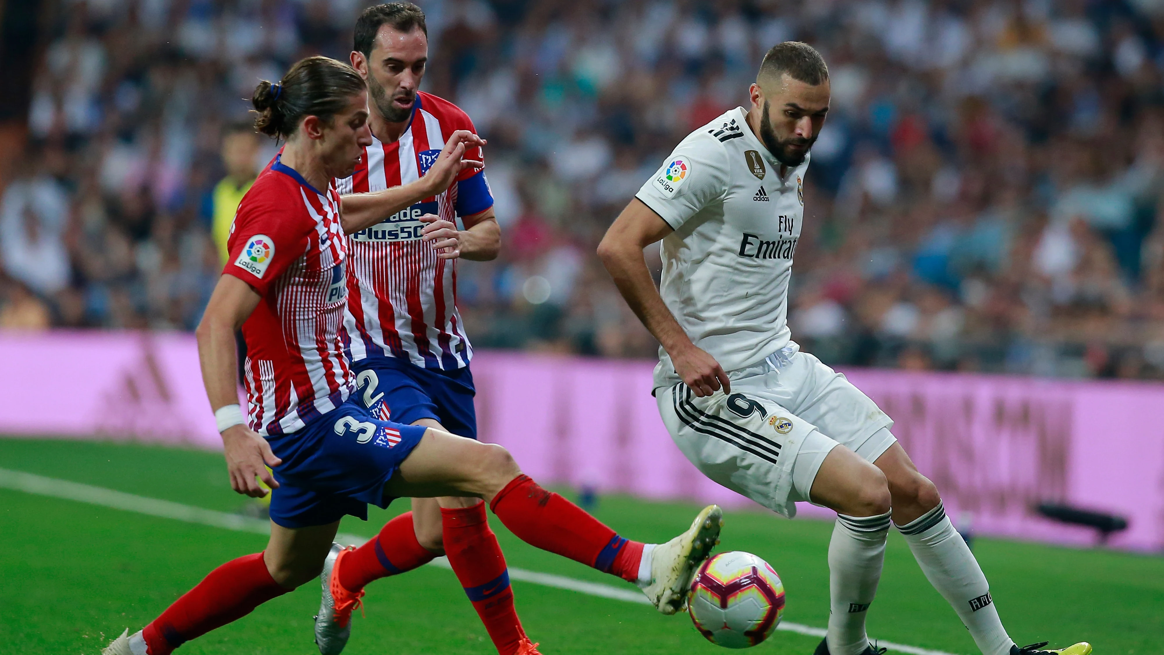 Benzema intenta zafarse de Filipe Luis y Godín