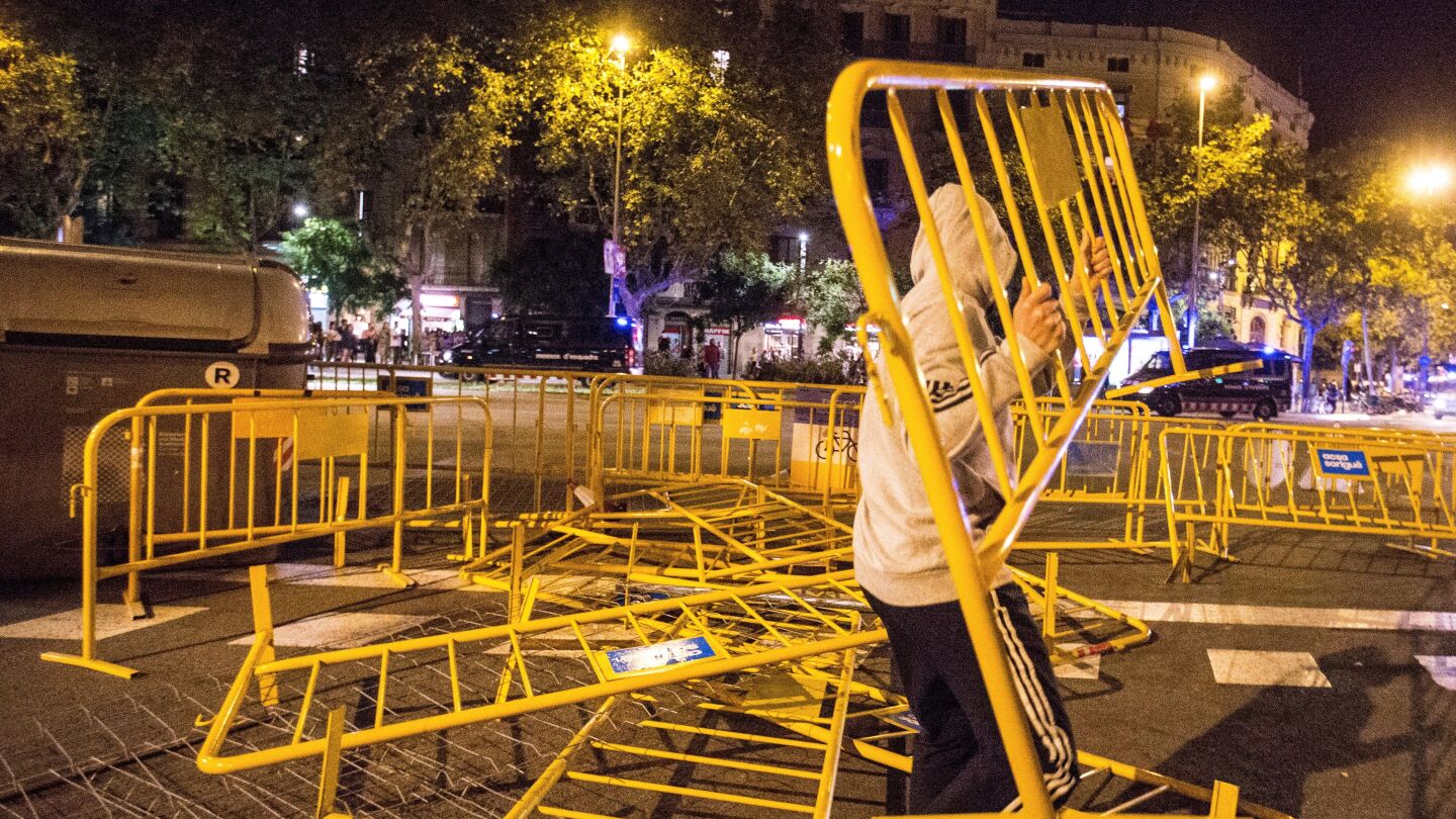 Un manifestante lanza una valla durante los altercados