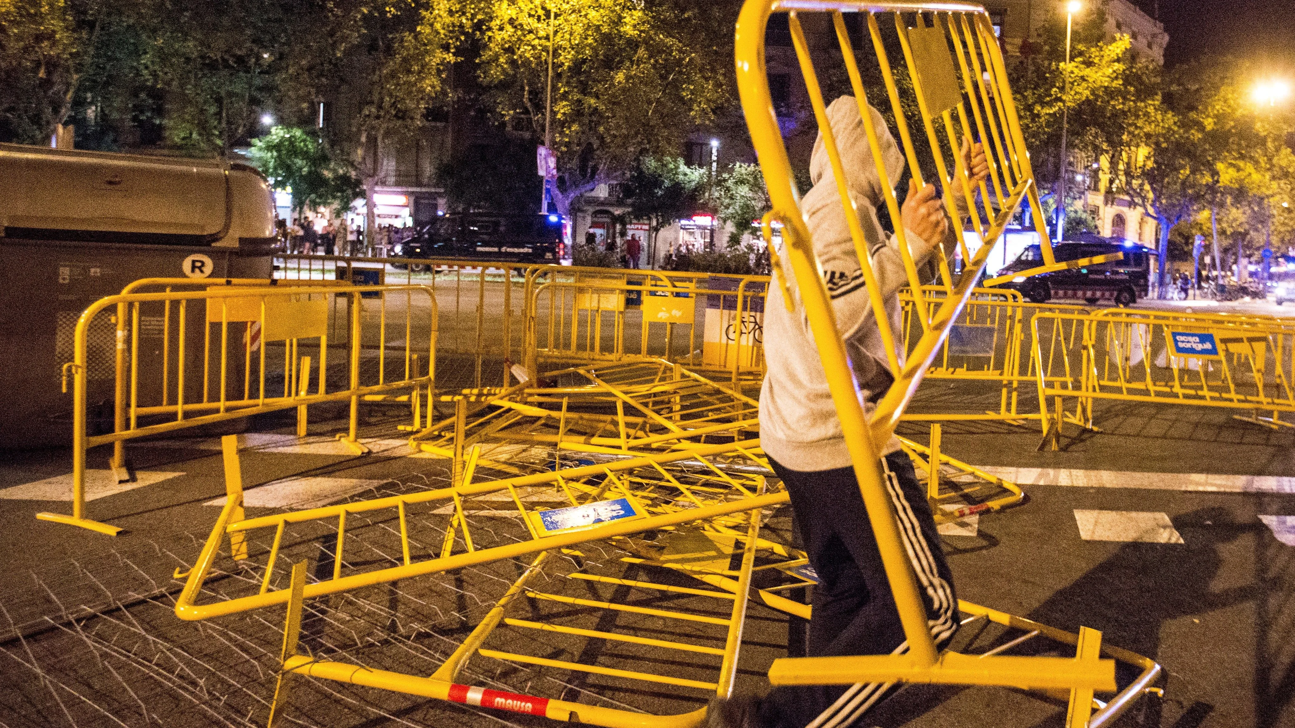 Un manifestante lanza una valla durante los altercados