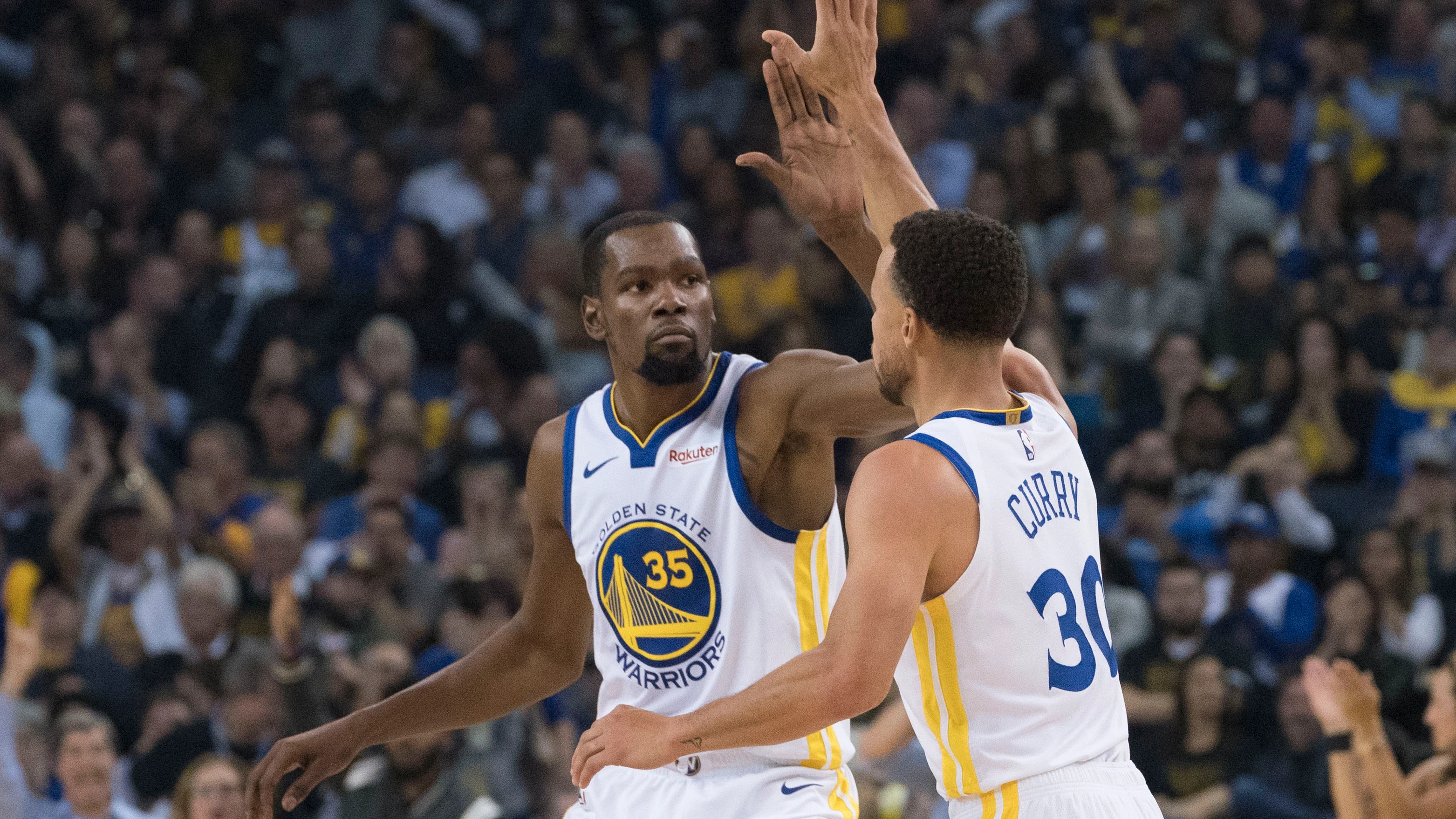 Curry y Durant celebran una canasta ante los Thunder