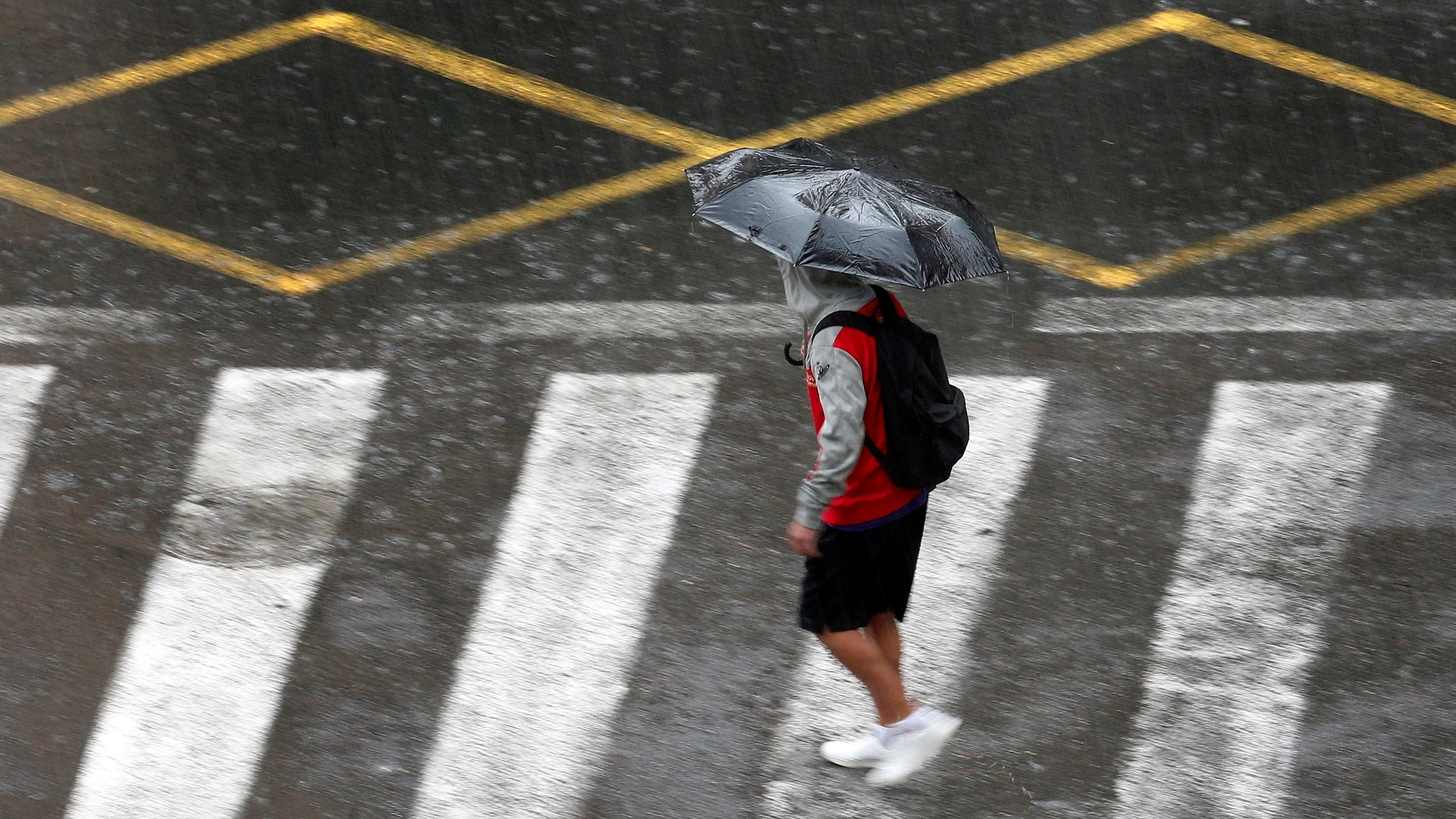 Una persona se protege de la lluvia con un paraguas