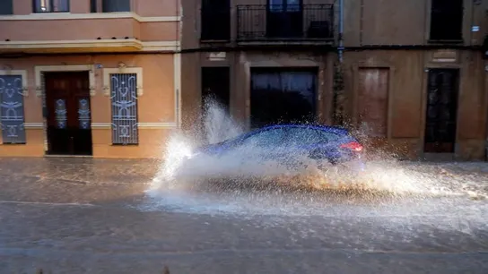 Un vehículo circula por una calle anegada de Valencia Un vehículo circula por una calle anegada de Valencia