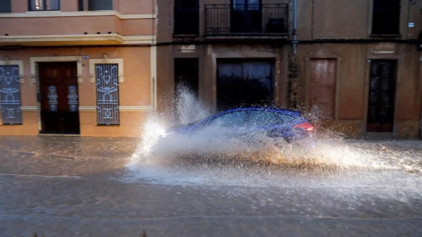 Un vehículo circula por una calle anegada de Valencia Un vehículo circula por una calle anegada de Valencia