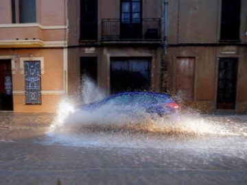 Un vehículo circula por una calle anegada de Valencia Un vehículo circula por una calle anegada de Valencia