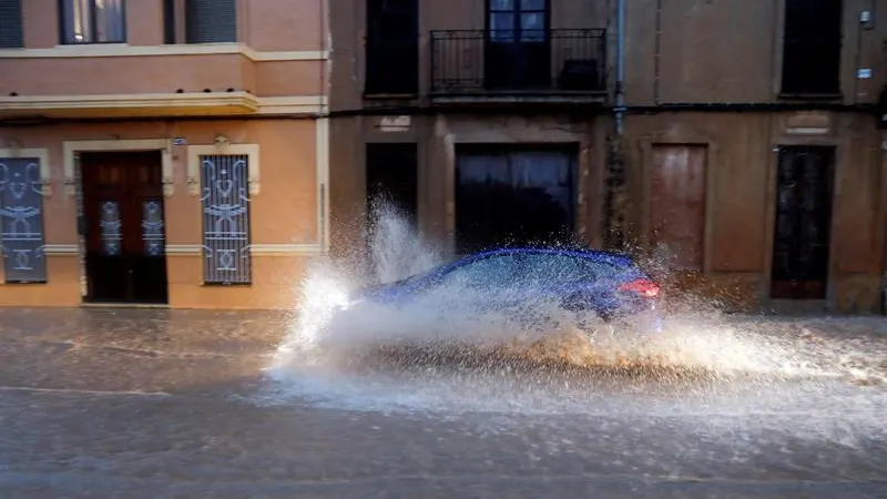 Un vehículo circula por una calle anegada de Valencia