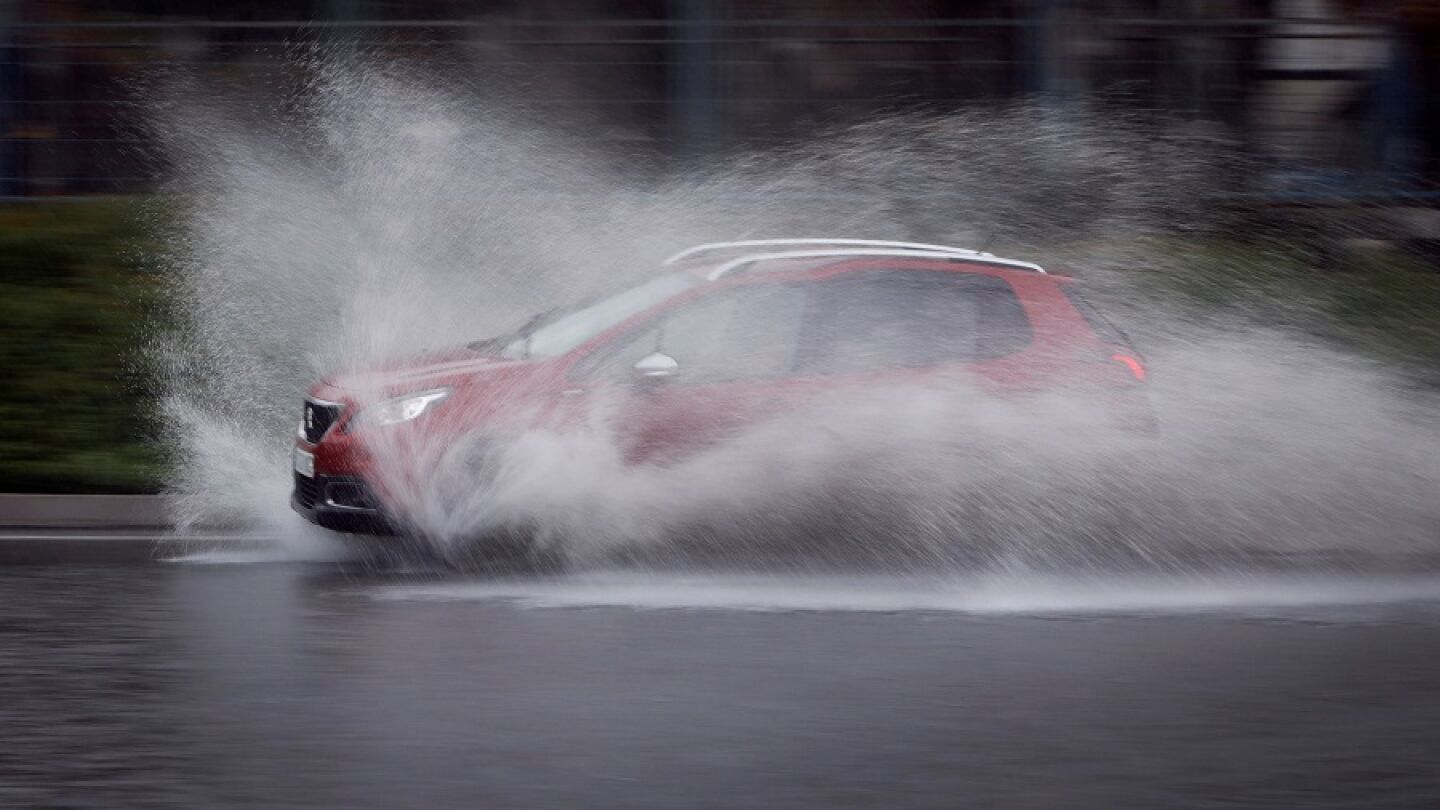 Imagen de un coche atravesando una calle anegada