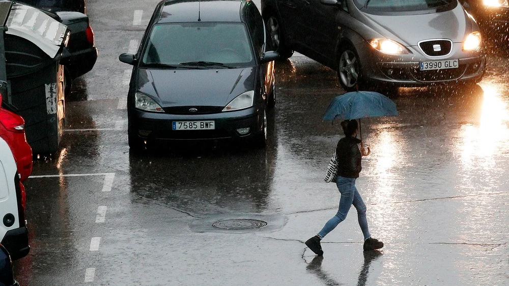 Imagen de una persona que se protege con un paraguas de la lluvia