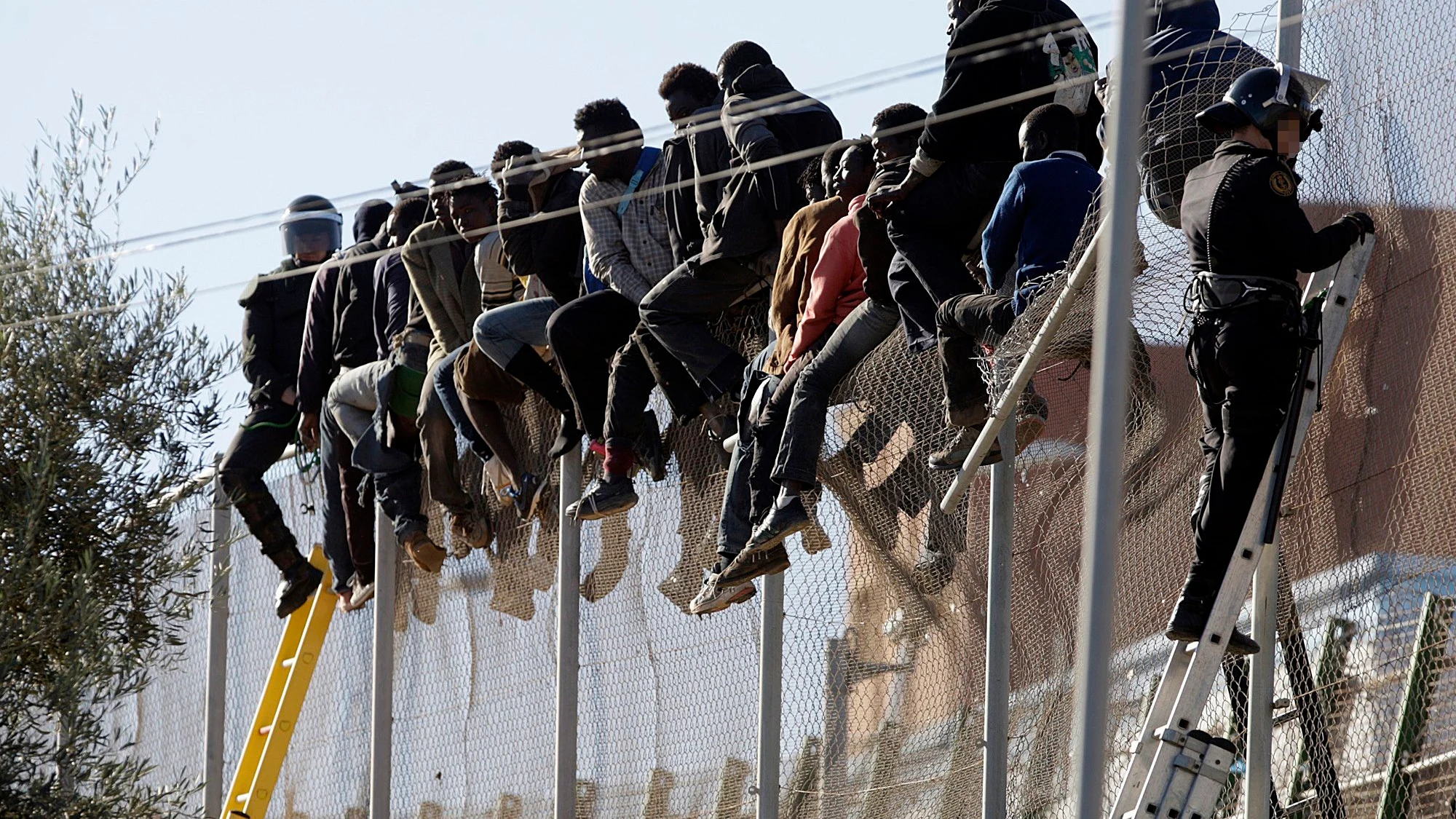 Varios subsaharianos en el vallado entre Melilla y Marruecos. 