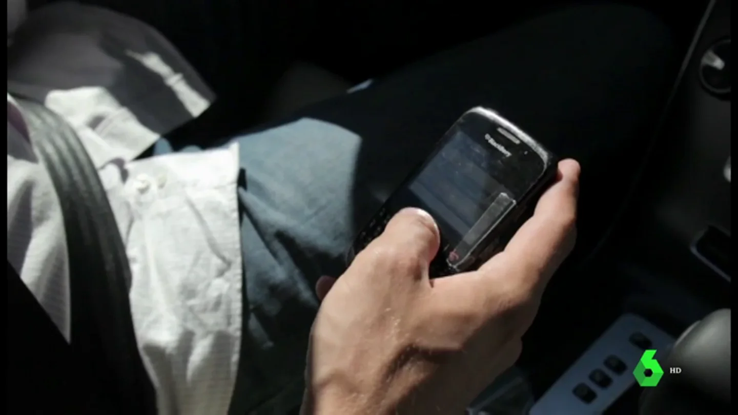 Un conductor utiliza el móvil al volante Un conductor utiliza el móvil al volante