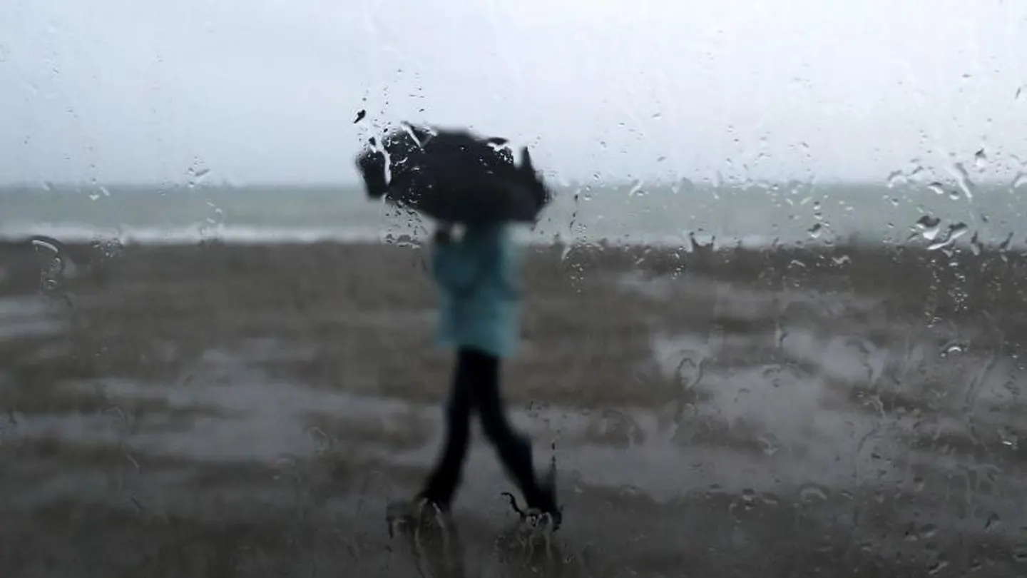 Un hombre se protege de la lluvia Un hombre se protege de la lluvia