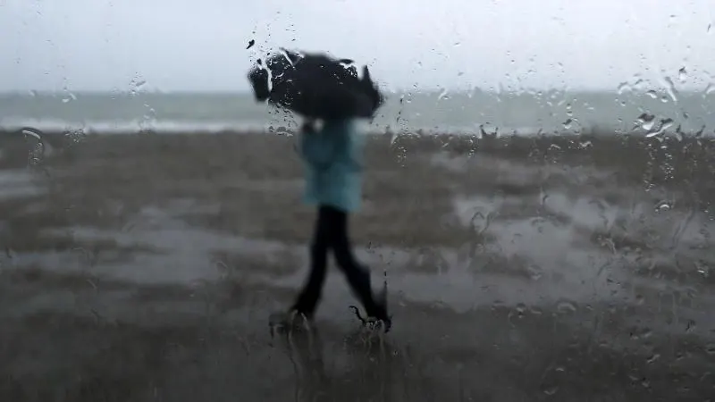 Un hombre se protege de la lluvia