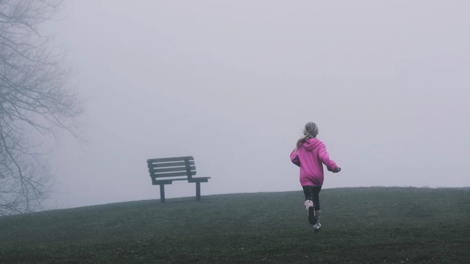 Niña corriendo sola en un parque