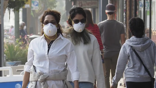 Personas caminando con mascarillas en Oakland, California Personas caminando con mascarillas en Oakland, California