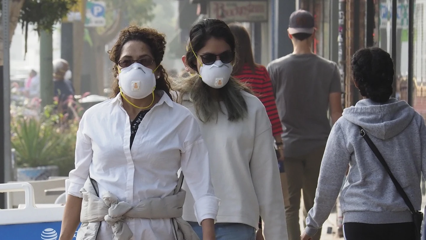 Personas caminando con mascarillas en Oakland, California Personas caminando con mascarillas en Oakland, California