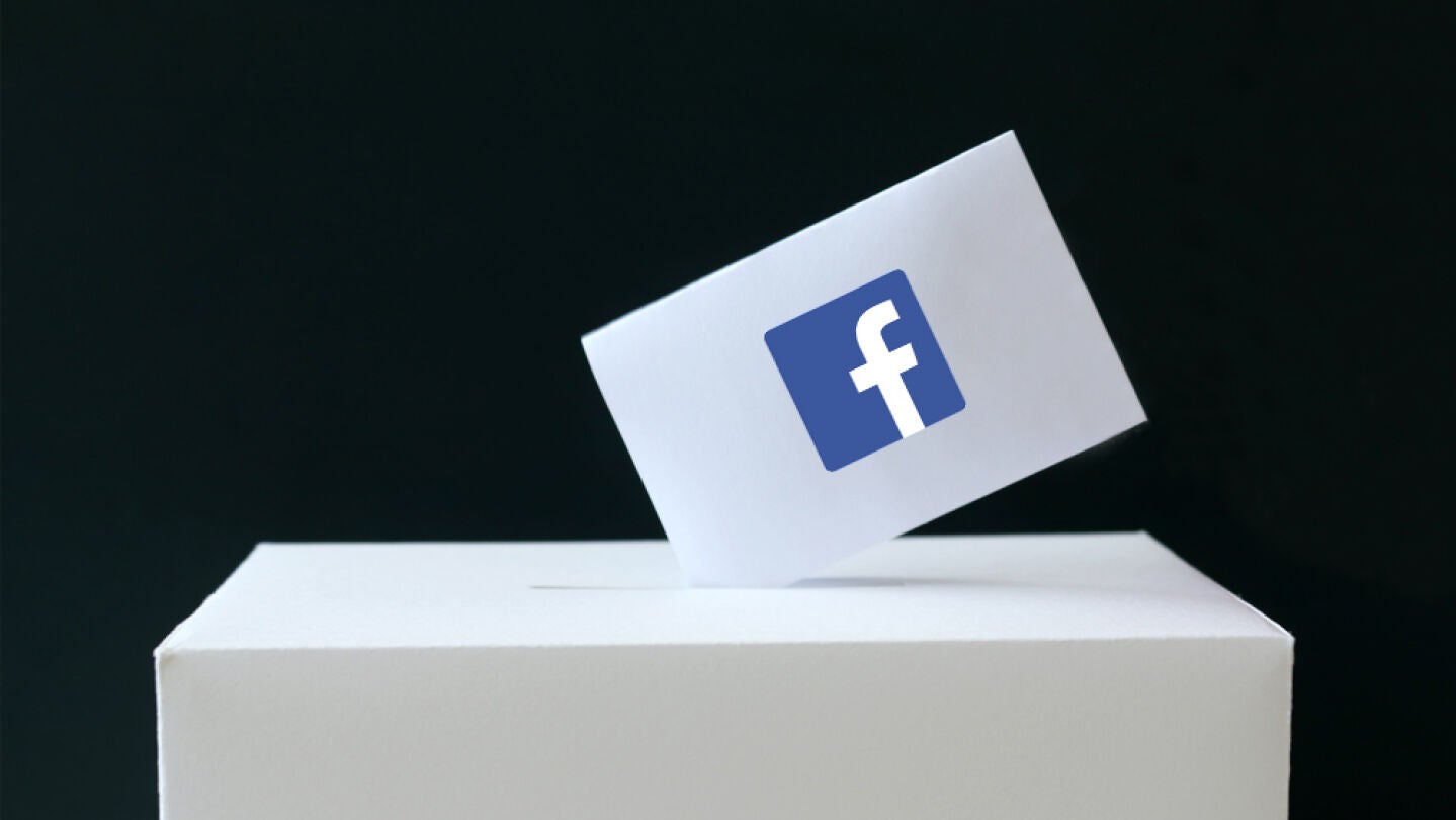 Papeleta con el s&iacute;mbolo de Facebook siendo depositada en una urna de votaciones