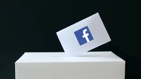 Papeleta con el símbolo de Facebook siendo depositada en una urna de votaciones Papeleta con el símbolo de Facebook siendo depositada en una urna de votaciones