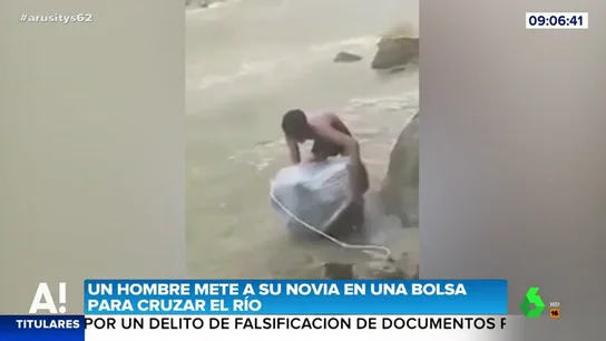 Las imágenes de un hombre que mete a su novia en una bolsa para cruzar un río Las imágenes de un hombre que mete a su novia en una bolsa para cruzar un río
