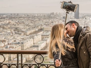 Pareja besándose mientras se hace un selfie Pareja besándose mientras se hace un selfie
