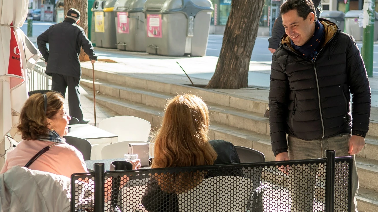 Juanma Moreno hablando con dos mujeres en la calle