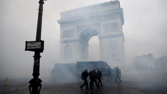 La polic&iacute;a francesa pasa ante el Arco del Triunfo tras los disturbios en Par&iacute;s