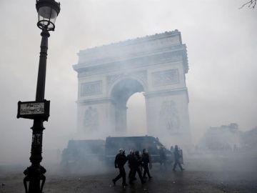 La policía francesa pasa ante el Arco del Triunfo tras los disturbios en París