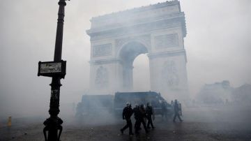 La policía francesa pasa ante el Arco del Triunfo tras los disturbios en París