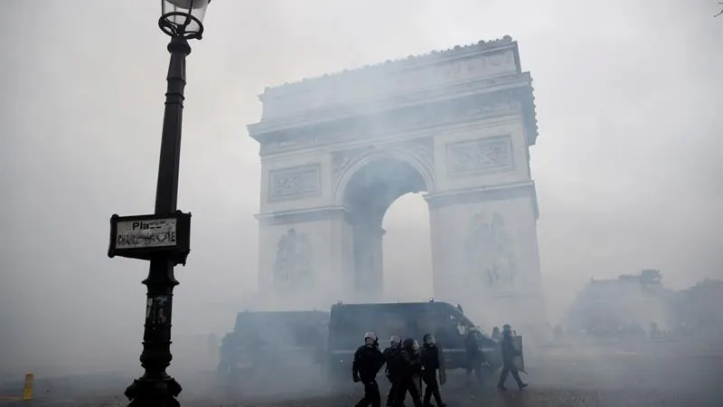 La policía francesa pasa ante el Arco del Triunfo tras los disturbios en París