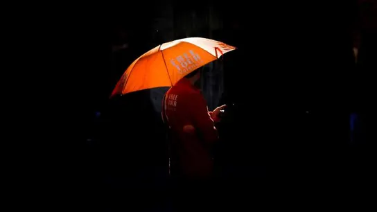 Una persona se protege del sol con un paraguas Una persona se protege del sol con un paraguas