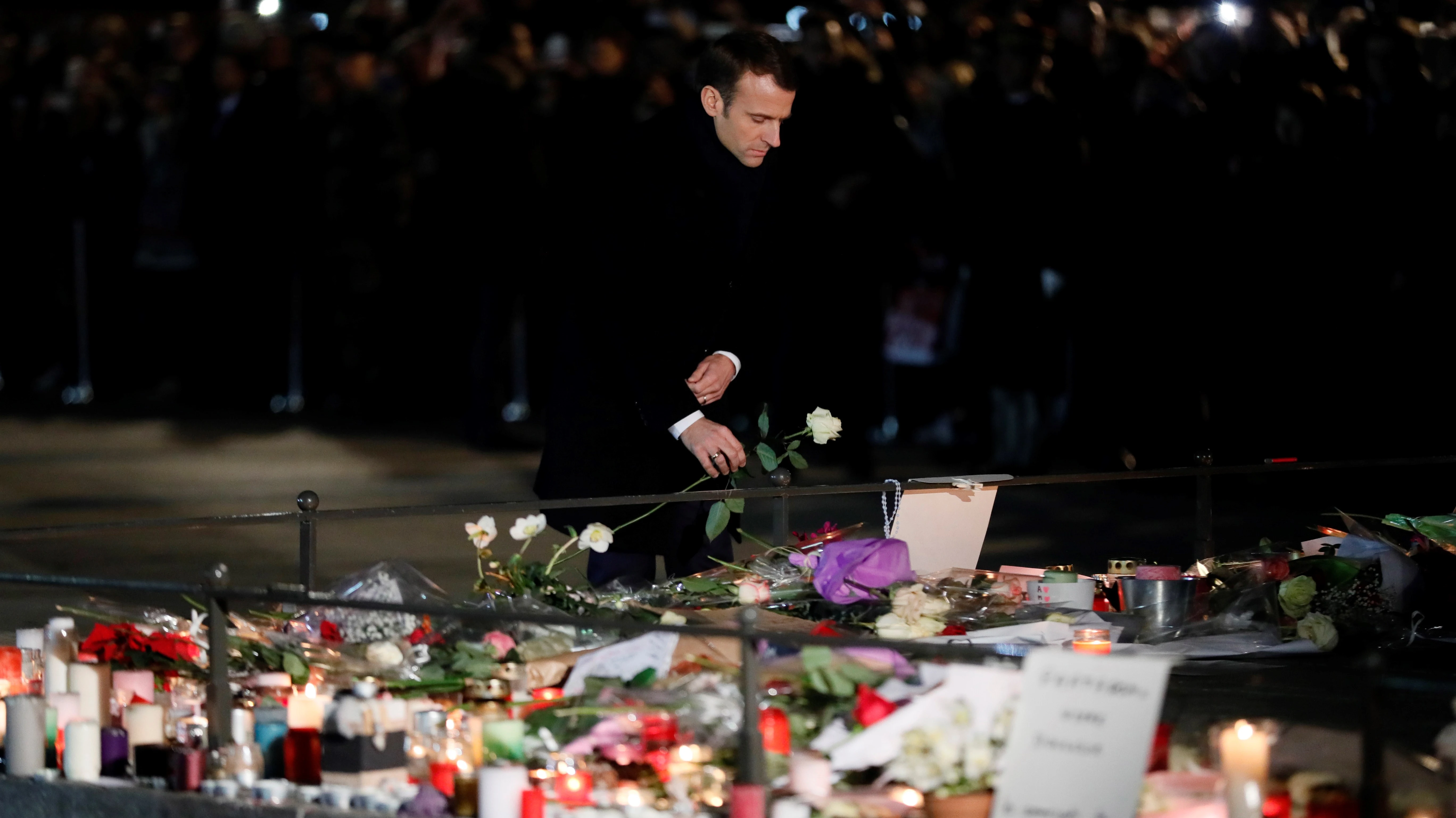 El presidente francés, Emmanuel Macron, deposita una flor en un recuerdo a las víctimas del atentado en Estrasburgo (Francia). 