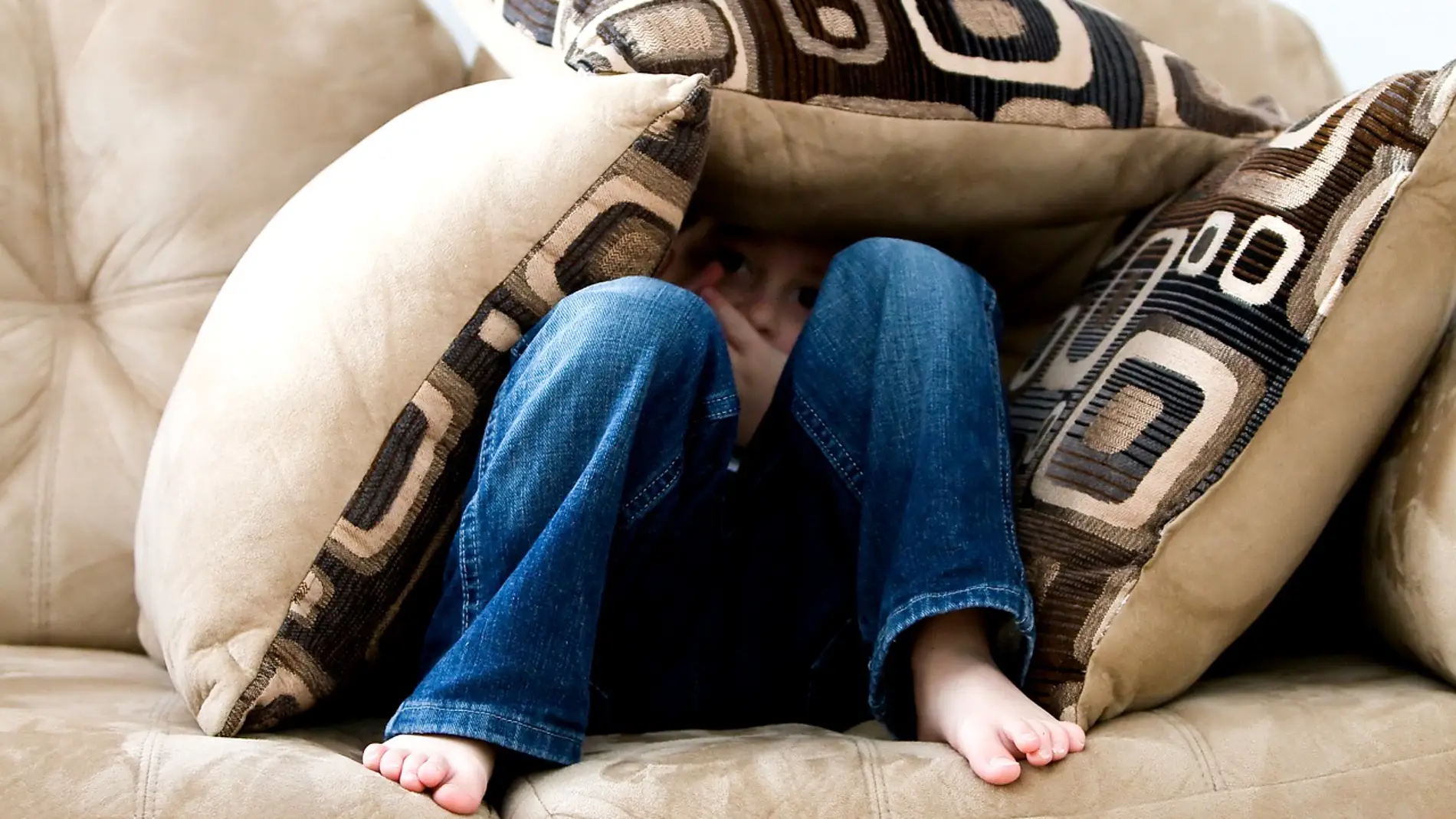 niño en un sofá con pies descalzos