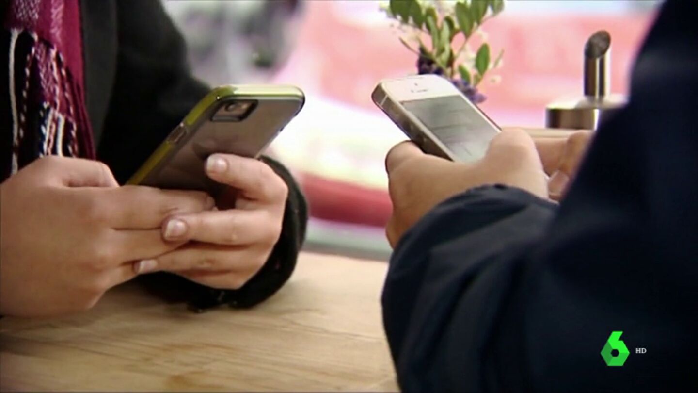 Dos personas con sus m&oacute;viles
