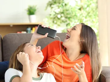 Chicas escuchan música en los auriculares Chicas escuchan música en los auriculares